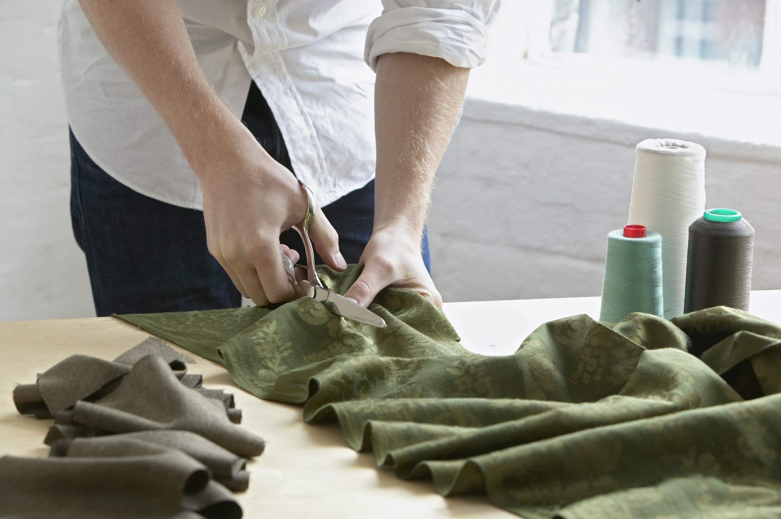 Midsection,Of,Young,Male,Tailor,Cutting,Piece,Of,Cloth,At starting a clothing brand